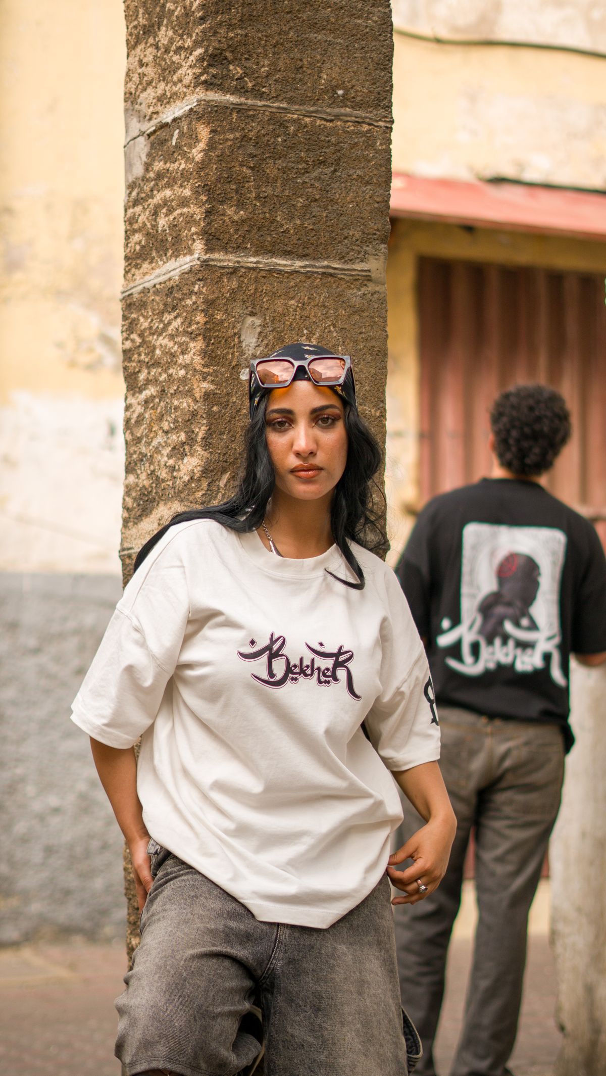 Two people wearing custom printed tees on a sunlit street