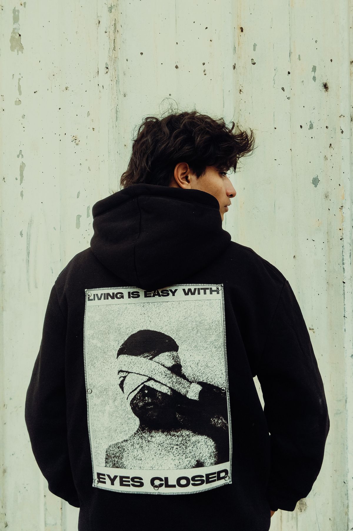 Back of a black hoodie carrying a large photographic print