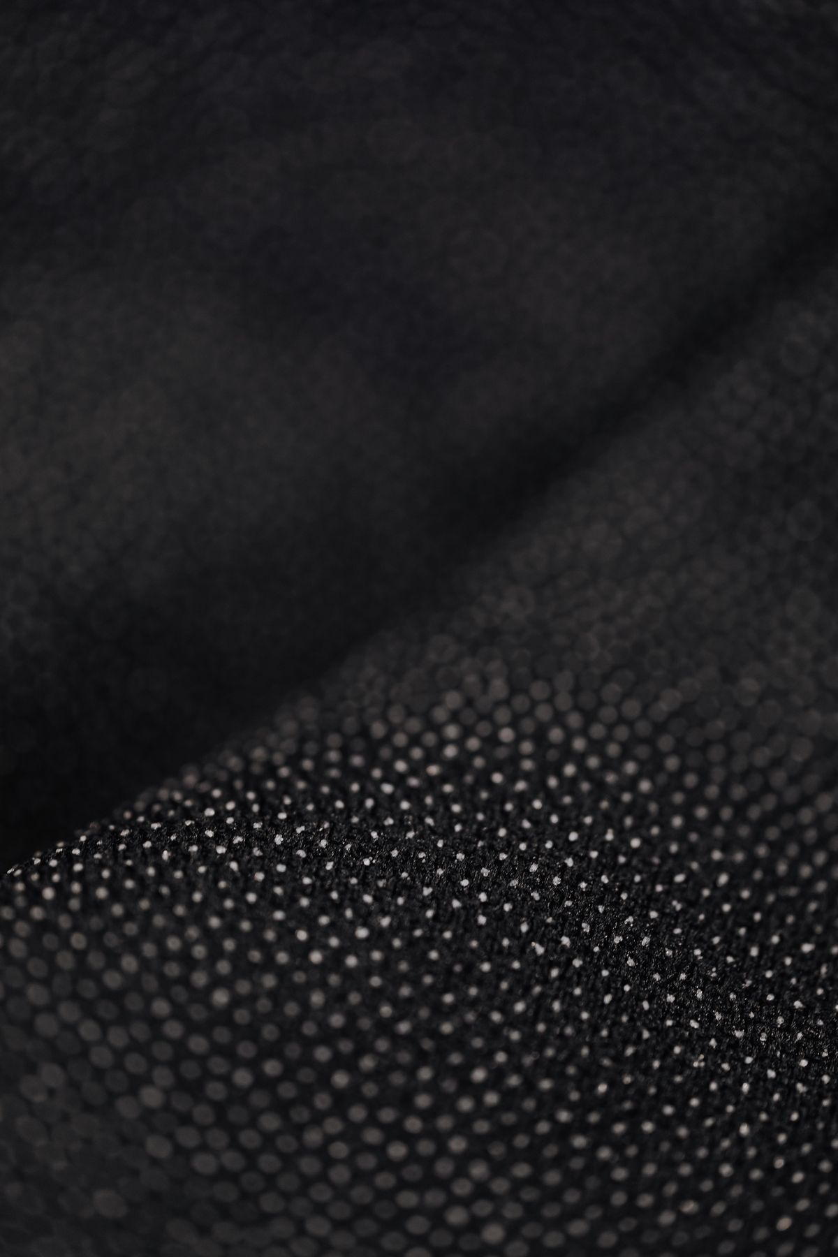 Close-up of black fabric with a fine dotted print
